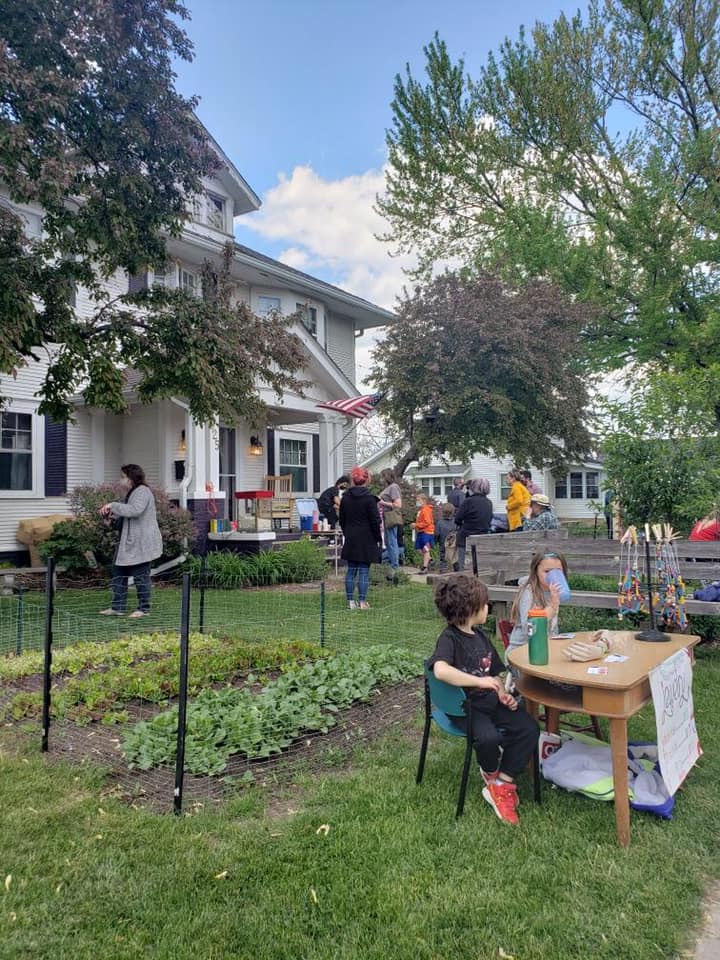 Main Street School students and adults working outdoors near the school garden