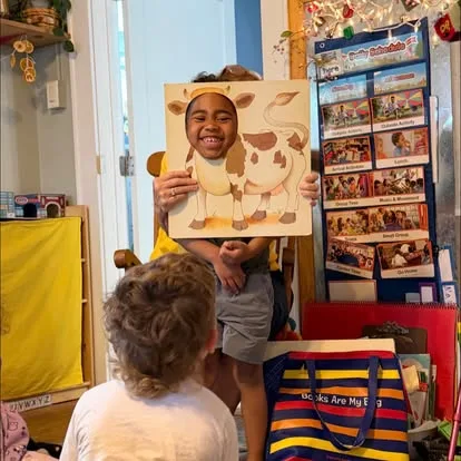 An elementary-age Main Street School student presenting a completed art project