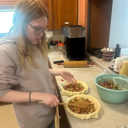 An older Main Street School student preparing food during a practical project