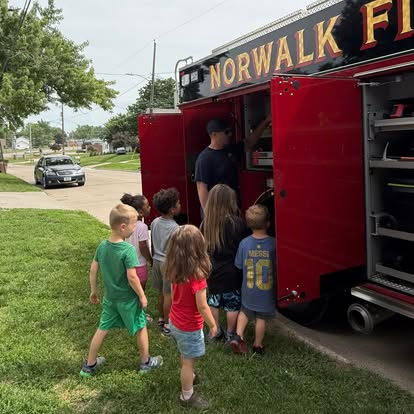 Students gathered beside a Norwalk fire truck during a community visit