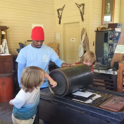 Elementary-age Main Street School students learning a hands-on process from a visiting instructor